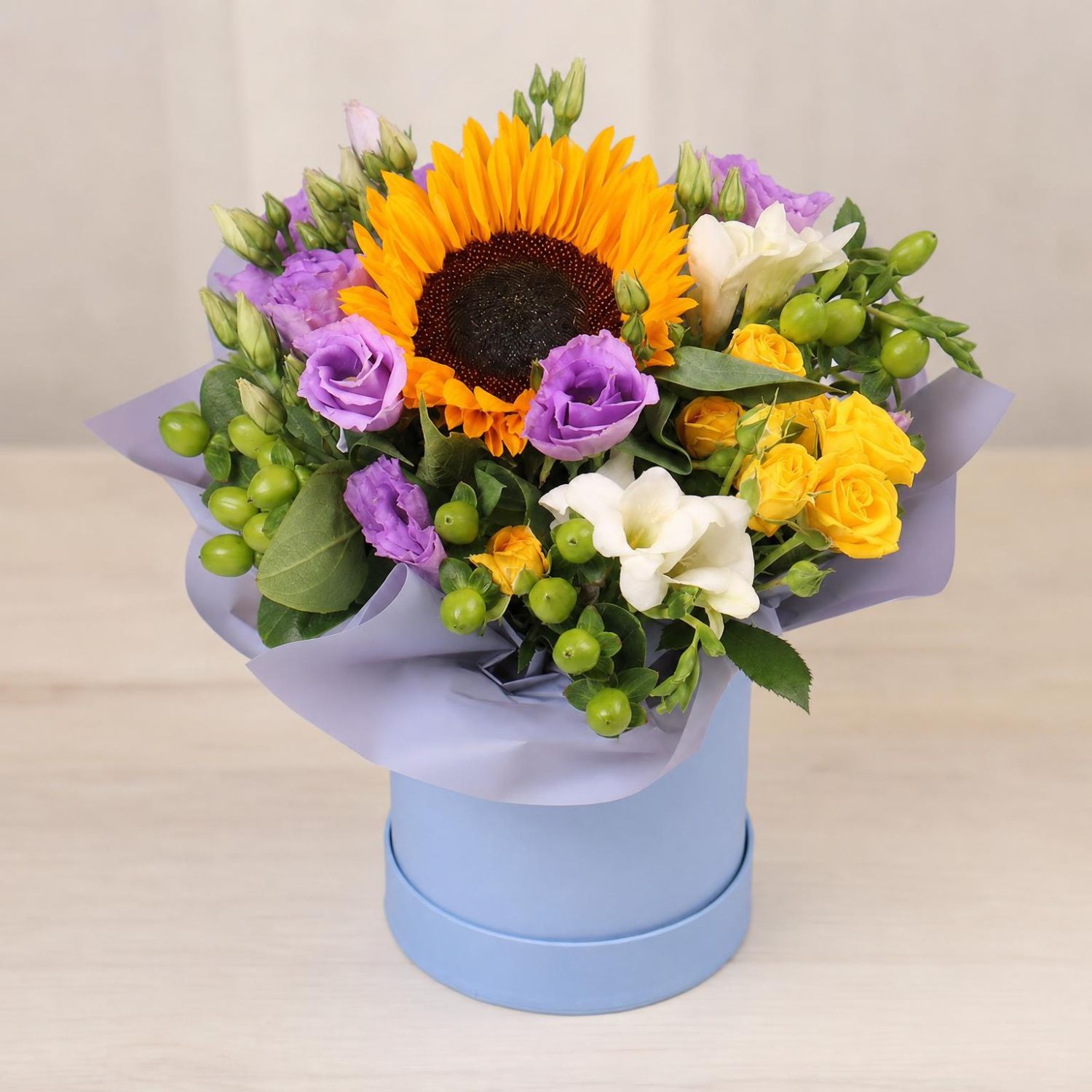 sunflower, eustoma (3 pcs.), freesia (2 pcs.), hypericum, oasis, spray rose, packaging, ribbon